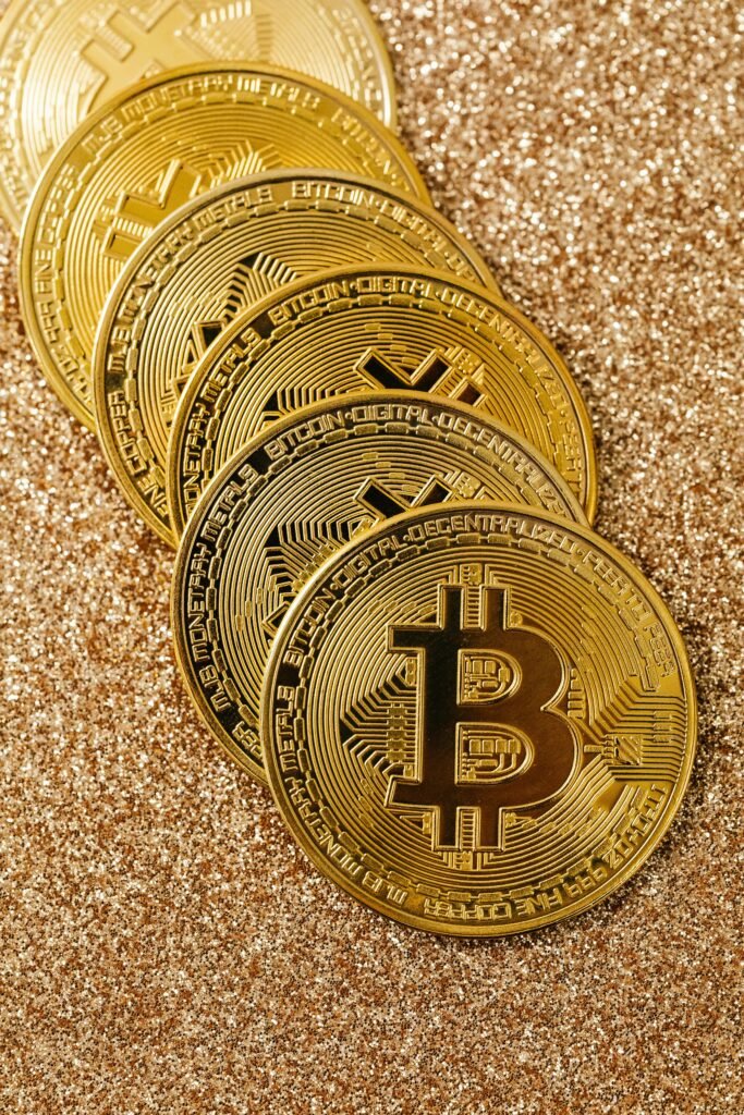 pexels-photo-5980585-5980585 Golden Bitcoin cryptocurrency coins stacked on a glittering surface representing digital wealth and blockchain.